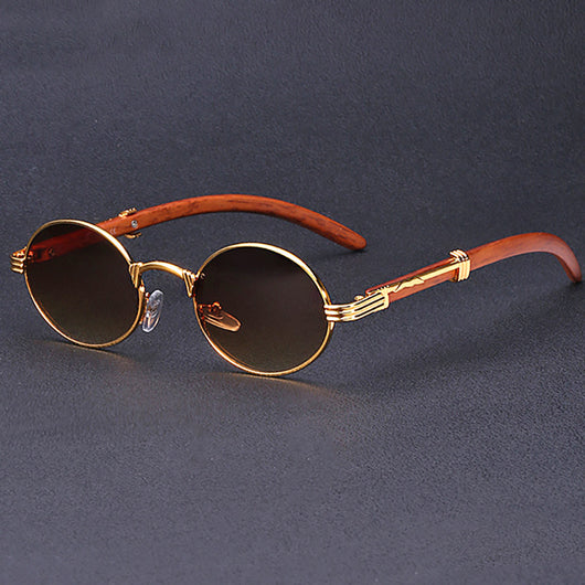 Retro oval sunglasses with gold metal frames and dark wood-like temples, featuring gradient black lenses.