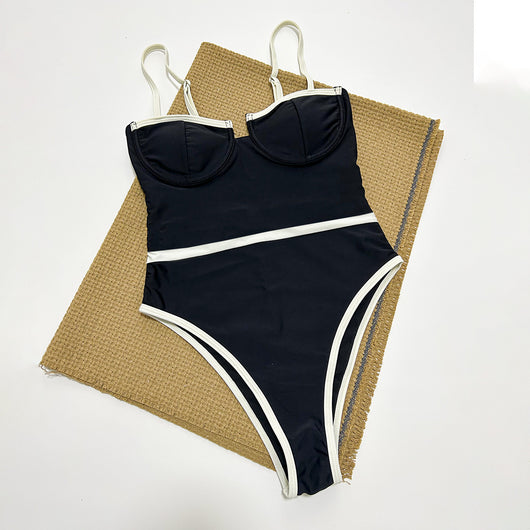Black one-piece swimsuit with white trim, thin straps, sweetheart neckline, and high-cut leg on a model. - Image 3