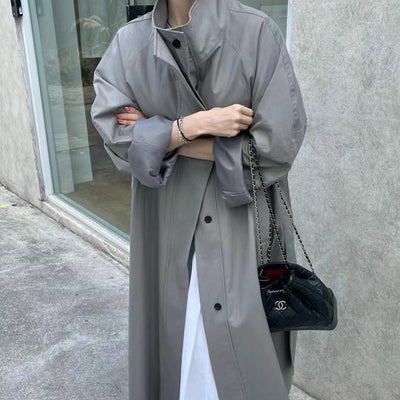 Gabardina Larga de Cuello Alto con Diseño Versátil y Elegancia Contemporánea