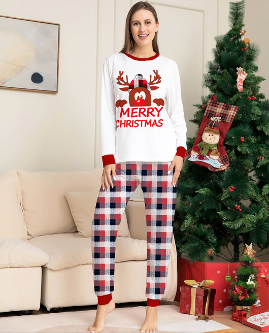 Young girl in a white long-sleeve Christmas pajama top with a reindeer graphic and red plaid pajama pants. - Image 9