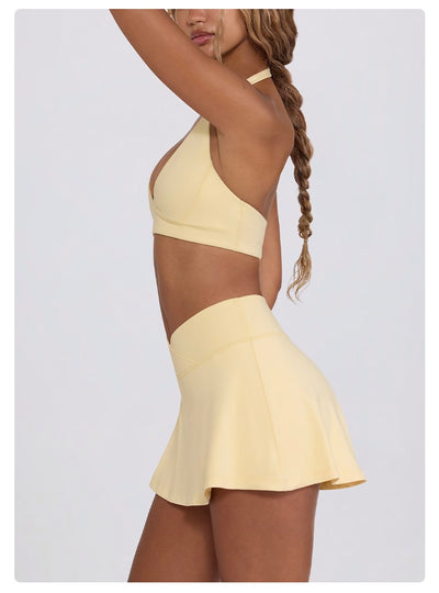 Light pink halter neck sports bra and high-waisted leggings workout set on a model. - Image 39