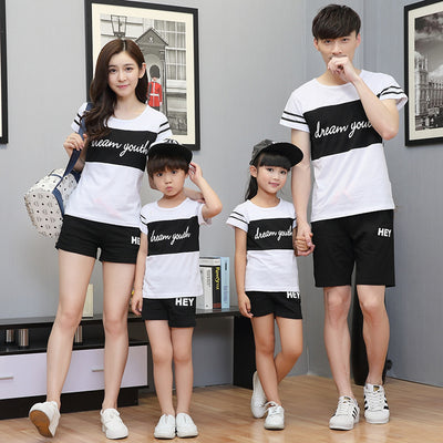 Young girl in a white short-sleeve t-shirt with a black stripe and black shorts, wearing a black cap. - Image 4