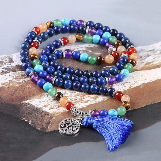Blue mala prayer beads with chakra colored gemstones, a silver Tree of Life charm, and a blue tassel. - Image 6