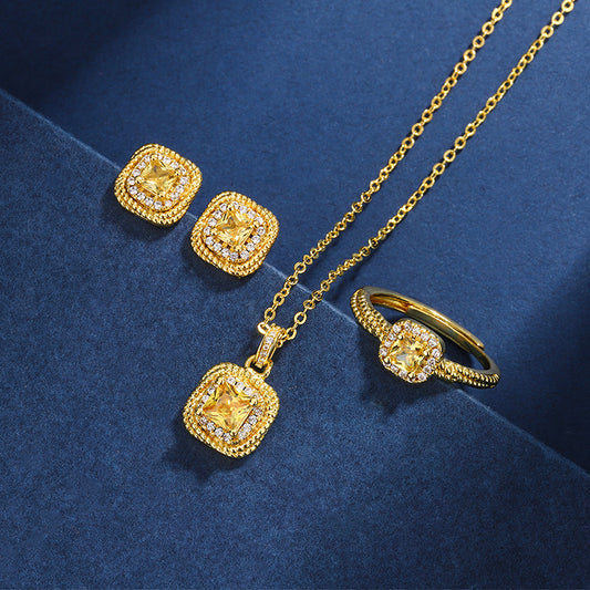 Women's gold-toned jewelry set with a ring, necklace, and stud earrings, each featuring a square yellow gemstone surrounded by small clear stones. - Image 2