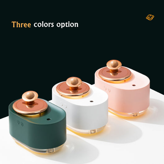 White USB rechargeable mini humidifier with a rose gold top accent and a wooden planet decoration. - Image 11