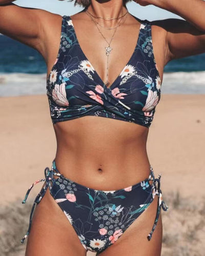 Navy blue floral print bikini with a twisted V-neck top and high-cut bottoms with adjustable tie sides. - Image 4