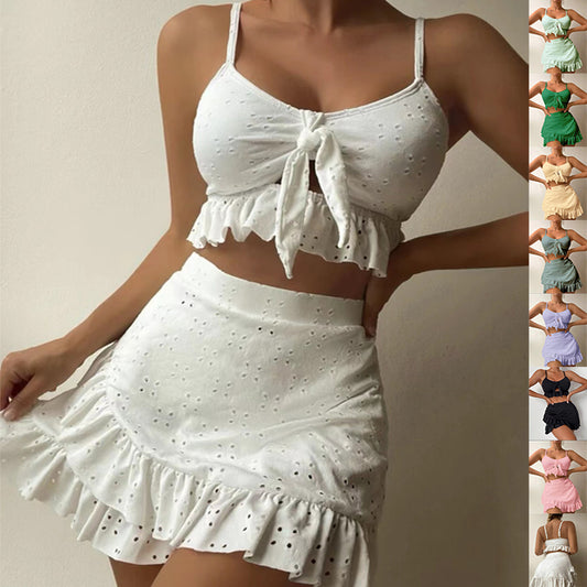 Light blue eyelet two-piece swimsuit set with a tie-front crop top and a matching ruffle-trim hip-hugging skirt.