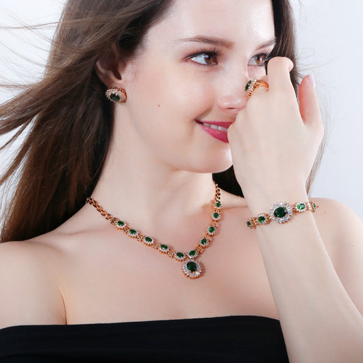 Rose gold tone jewelry set with oval blue gemstones and clear accents, including a necklace, bracelet, earrings, and ring. - Image 4