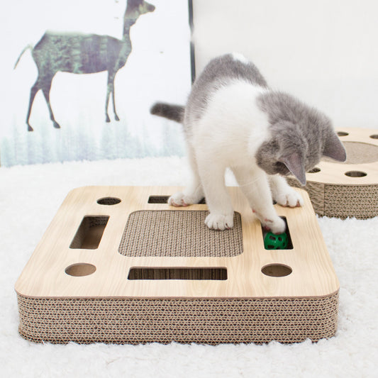 Round corrugated cardboard cat scratcher with a central scratching pad and multiple holes containing colorful balls.