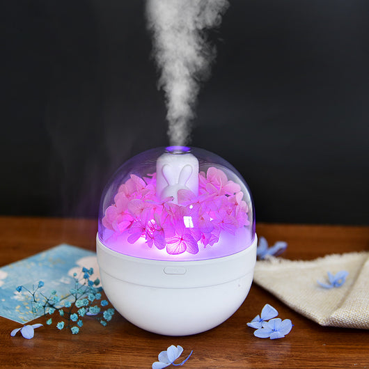 White spherical aroma diffuser with clear dome, featuring preserved blue roses, blue hydrangea, and a white rabbit figurine. - Image 5