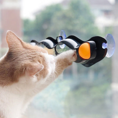 Grey plastic wavy track ball cat toy with two orange balls and suction cups for window or wall mounting. - Image 8