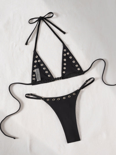 Black tie-front bikini swimsuit with silver grommets on the triangle top and a ruched thong bottom, laid flat. - Image 14