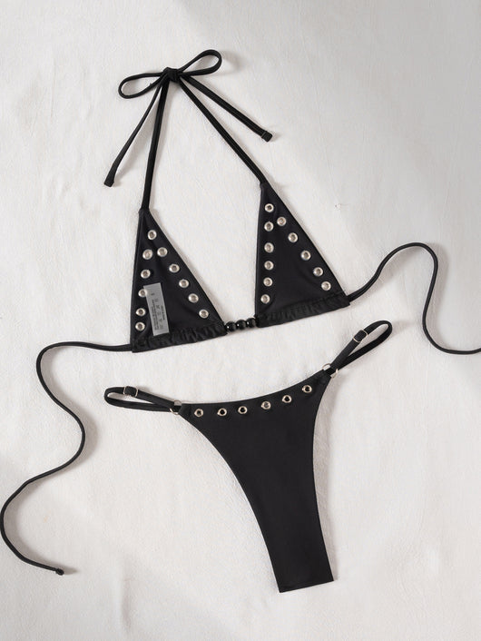 Black tie-front bikini swimsuit with silver grommets on the triangle top and a ruched thong bottom, laid flat. - Image 14