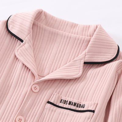 Beige ribbed cotton children's pajama set with long-sleeved lapel top and matching pants, featuring black trim. - Image 13