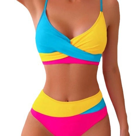 Woman wearing a blue color block split swimsuit with a wrapped front bikini top and high-waisted briefs. - Image 2