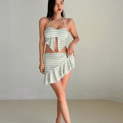 Woman in a light green and white striped two-piece swimsuit with a halter top and V-cut front hem. - Image 3