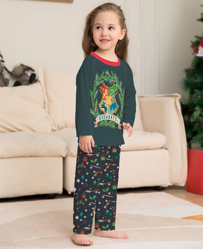 Family of four wearing matching dark green Hogwarts pajamas with a festive Harry Potter pattern, posing by a Christmas tree. - Image 5