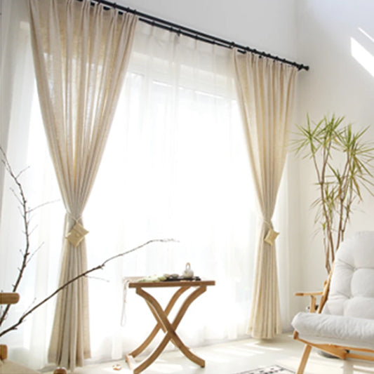 Close-up of a natural linen half-shade curtain with a textured weave and soft folds, paired with dried baby's breath flowers.