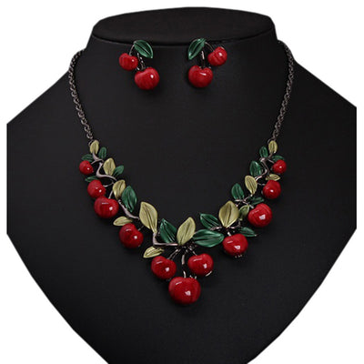 Cherry necklace and earring set featuring red enamel cherries and green leaves on a dark chain, displayed on a black bust. - Image 10