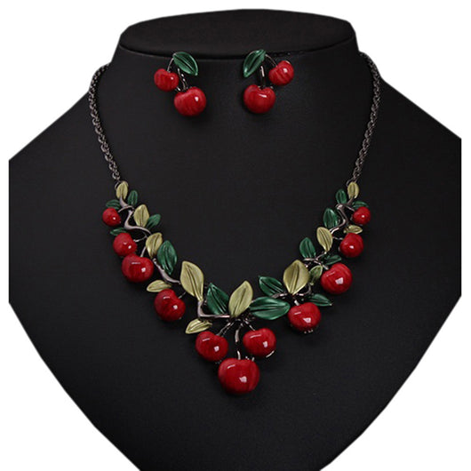 Cherry necklace and earring set featuring red enamel cherries and green leaves on a dark chain, displayed on a black bust. - Image 10
