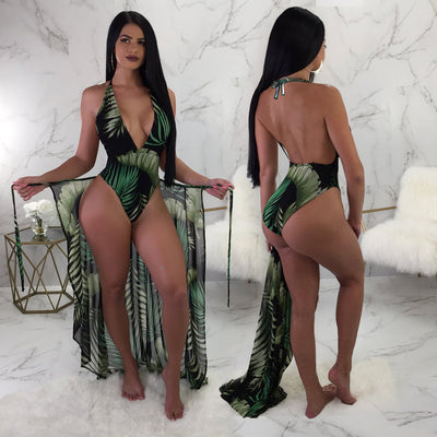 Woman in a black one-piece swimsuit with green leaf print, plunging V-neck, and matching sheer sarong cover-up. - Image 10