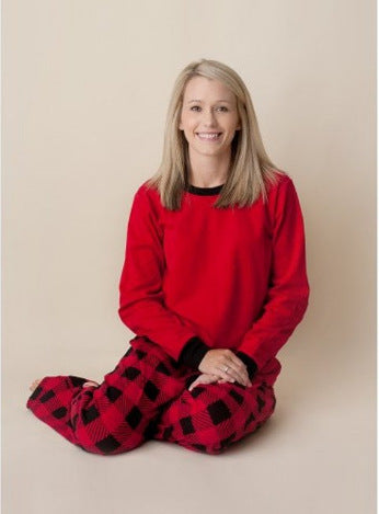 Family of four wearing matching red and black buffalo plaid Christmas pajamas, featuring solid red long-sleeve tops and plaid pants. - Image 2