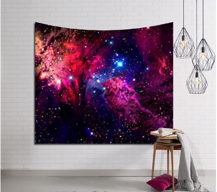 Vibrant deep space tapestry with a colorful nebula and star field design, hung on a white brick wall.