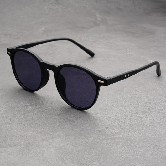 Fashionable round-frame sunglasses with transparent gray frames and dark gray lenses on a gray surface. - Image 11