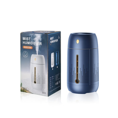 White cylindrical household humidifier with a visible water level indicator, next to its brown cardboard packaging. - Image 10