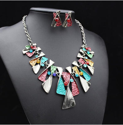Silver and blue abstract fashion necklace and matching stud earrings set with blue rhinestones on a black mannequin. - Image 3