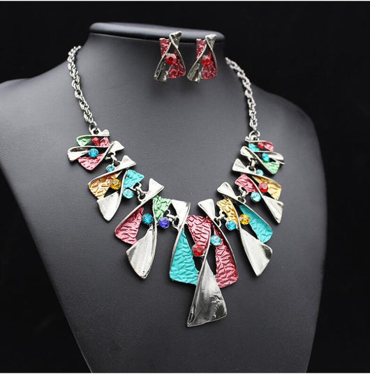 Silver and blue abstract fashion necklace and matching stud earrings set with blue rhinestones on a black mannequin. - Image 3