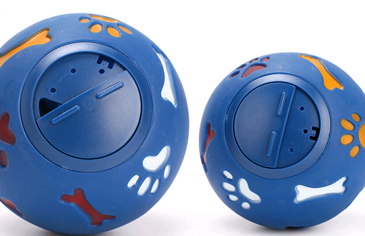 Red rubber pet puzzle ball with white, blue, and orange paw print and bone cutouts, featuring a treat dispenser opening. - Image 5