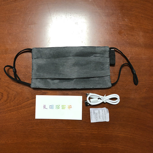White LED mask with adjustable ear loops, a USB charging cable, and an instruction manual on a wooden surface. - Image 8