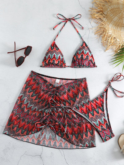 Three-piece printed swimsuit with a red and teal abstract pattern, featuring a halter bikini top, bottom, and mesh wrap skirt with drawstring. - Image 10