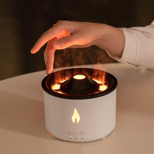 White ultrasonic essential oil diffuser with orange flame effect mist, alongside a gift set of Lavender, Peppermint, Tea Tree, and Sweet Orange essential oils.