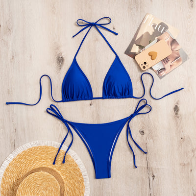 Neon yellow halter bikini with triangle top and tie-side bottoms, displayed on a light wood surface. - Image 12