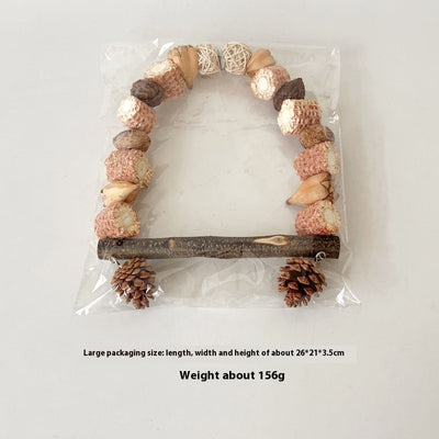 Natural wooden parrot swing with an arched top made of corn cobs, seed pods, and woven balls, featuring a log perch and two hanging pine cones. - Image 10