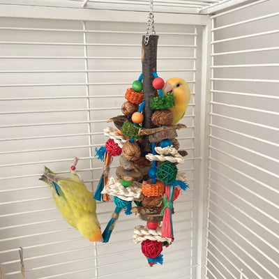 Hanging parrot toy made from natural wood, corn husk, and nuts with colorful strings and beads. A small yellow bird perches on the toy. - Image 4