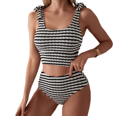 Women's black and white striped two-piece swimsuit with a tube top and high-waisted bottoms, worn by a person lounging on a white bed. - Image 5