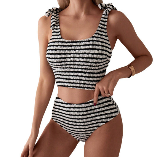 Women's black and white striped two-piece swimsuit with a tube top and high-waisted bottoms, worn by a person lounging on a white bed. - Image 5