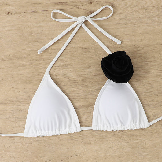 Woman wearing a white triangle bikini with a large 3D flower on the top and a smaller one on the bottom. - Image 17