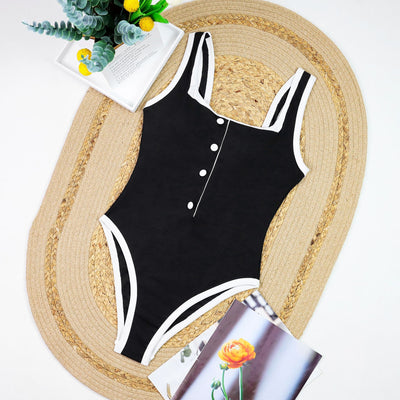 Woman in a white one-piece swimsuit with black trim and decorative buttons, sitting on a boat. - Image 19