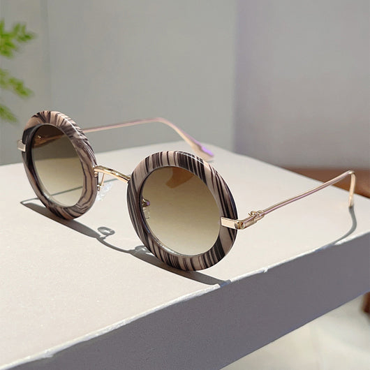 Small frame oval fashion sunglasses with black frames and vibrant orange lenses, held by a hand. - Image 25