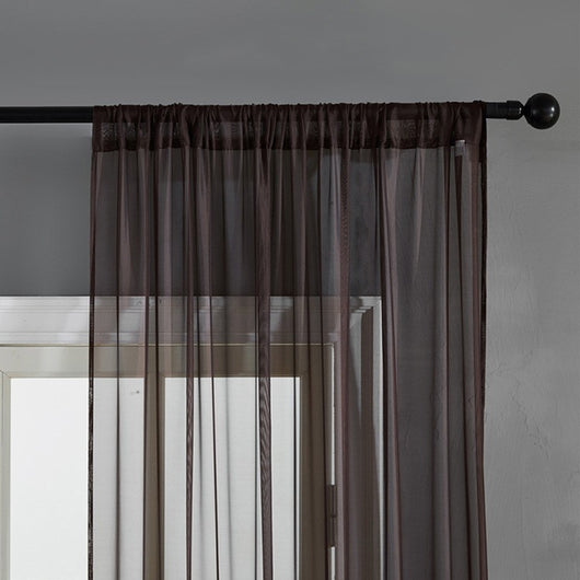 Sheer pink rod pocket curtain hanging on a black curtain rod, offering light transmission for a modern room. - Image 10