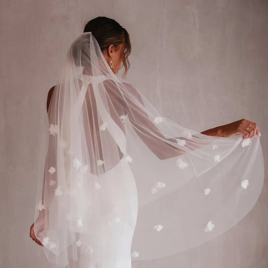 White and ivory sheer fabric swatches for a wedding veil displayed on green grass. - Image 2