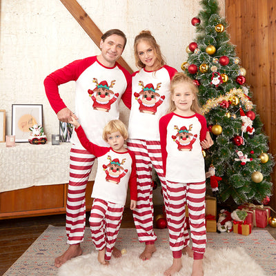 Family matching Christmas pajamas with red raglan sleeve tops featuring a cartoon reindeer and red and white striped pants.