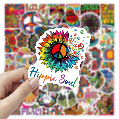 A hand holds a vibrant, tie-dye butterfly sticker with a black outline, against a blurred background of many other colorful, hippie-style stickers. - Image 2