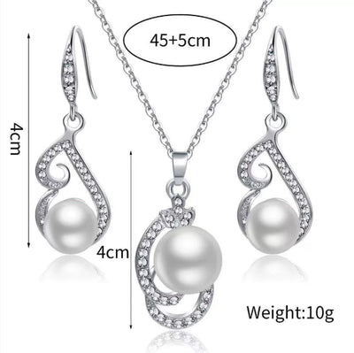 Silver-tone rhinestone and faux pearl drop necklace and matching earrings jewelry set on a black background. - Image 5