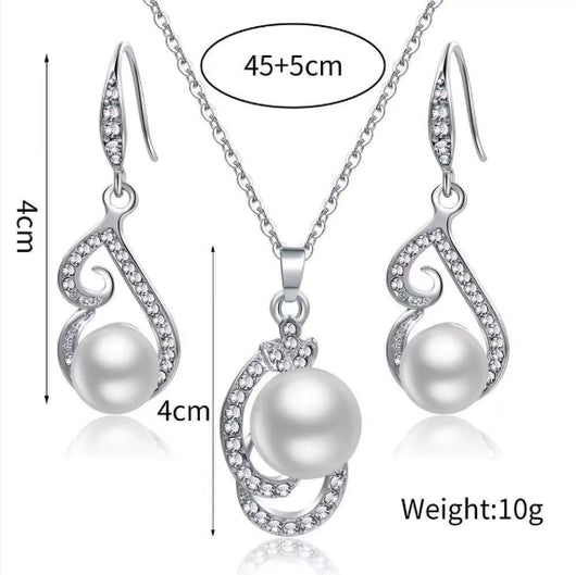 Silver-tone rhinestone and faux pearl drop necklace and matching earrings jewelry set on a black background. - Image 5
