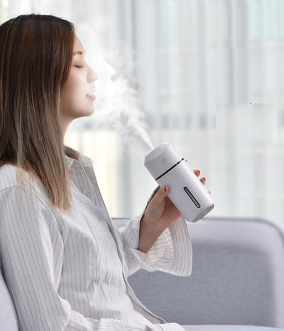 Pink portable humidifier with a power button, water level indicator, USB charging cable, and two cotton swabs. - Image 11